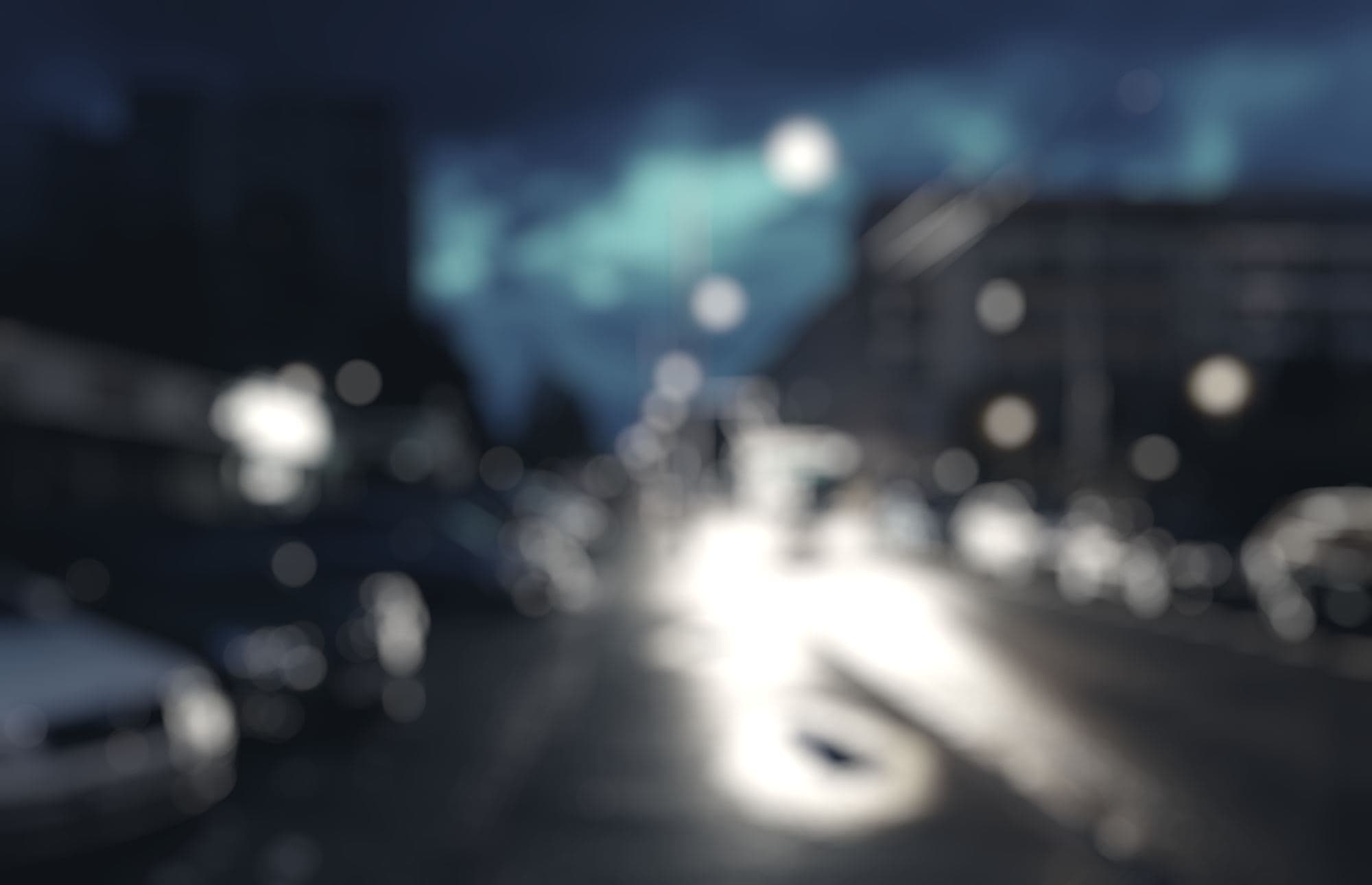 Sídliště v noci, pouliční lampy a světla aut, rozostřeně